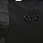 جزئیات لوگوی برجسته ALO روی ساک ورزشی مشکی